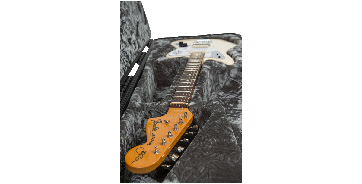 Close-up of Jaguar Jazzmaster guitar headstock inside Waterproof Guitar Case, highlighting secure neck support and plush lining.