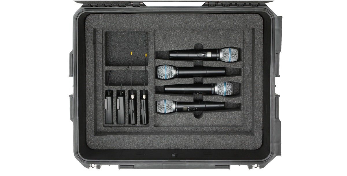 Organized interior of 2U Wireless Mic Fly Rack with six wireless microphones and transmitters in custom foam slots.