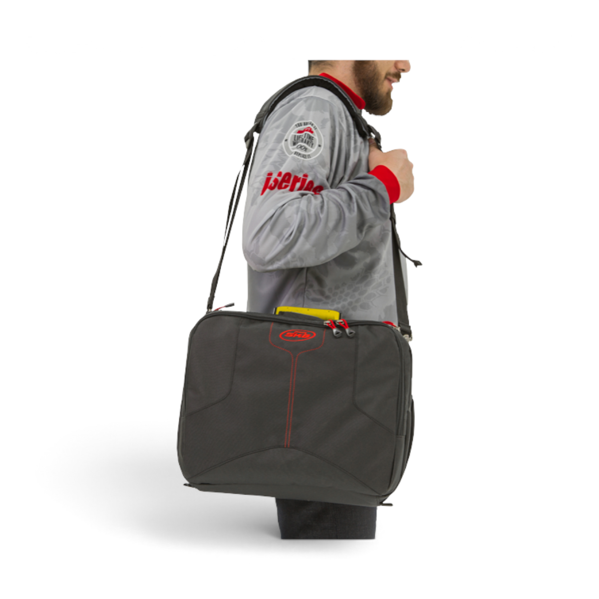A man wearing an SKB Cases iSeries 1309-6 large lure case with a shoulder strap over a grey fishing jersey.