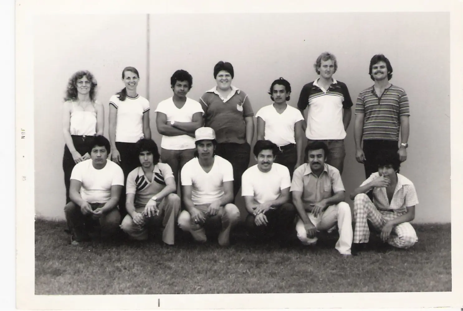 Black and white photo of a group of people posing outdoors.
