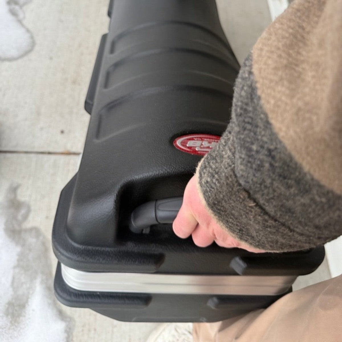 SKB Cases Deluxe Standard ATA golf travel case in black with a sturdy handle being held for transport.